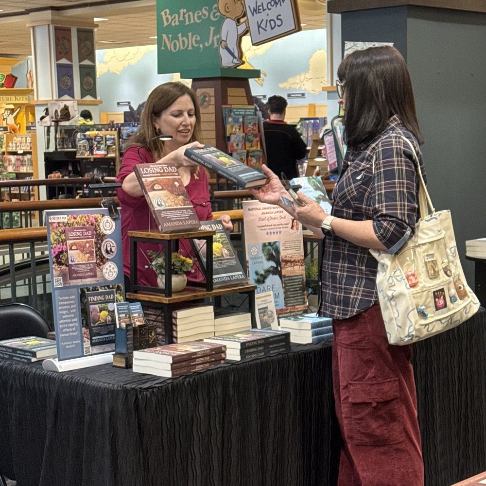 Amanda LaPera talking with a reader at a Barnes & Noble book display.