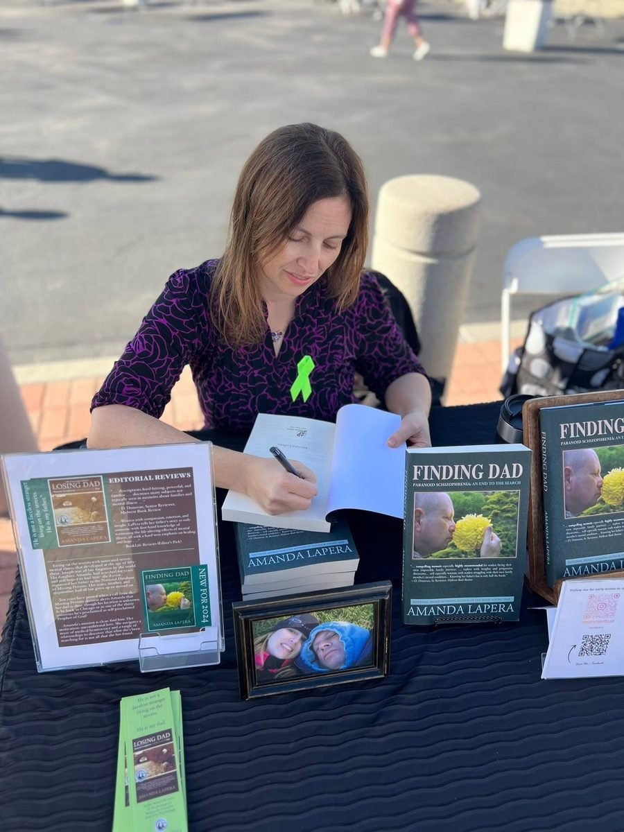 Amanda LaPera signing books at an outdoor reader event.